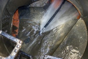 When is water (hydro) jetting necessary for clearing a clog?